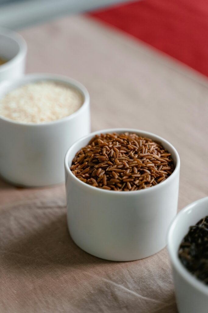 Close-up of a variety of grains in white cups, showcasing textures and colors.